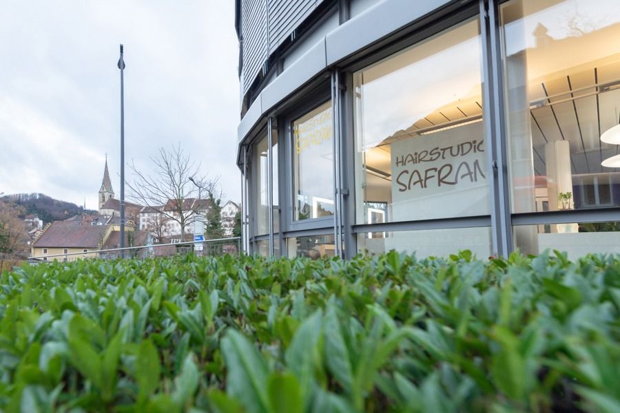 Eine Frau lässt sich in einem Salon von einem Friseur die Haare färben.