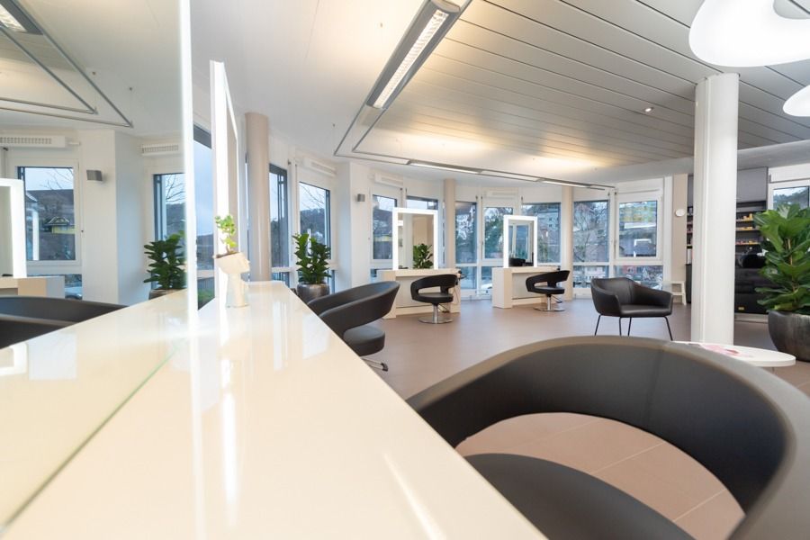 Ein Salon mit vielen Stühlen und Spiegeln