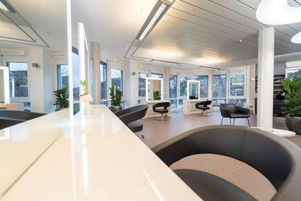 Ein Salon mit vielen Stühlen und Spiegeln