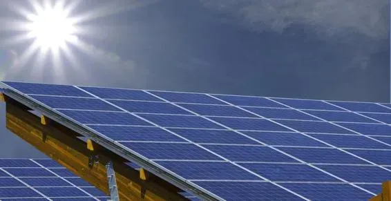 Panneaux solaires sous un soleil, avec un ciel et des nuages.