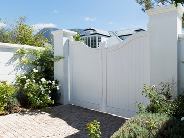Double portail blanc dans une cour-jardin