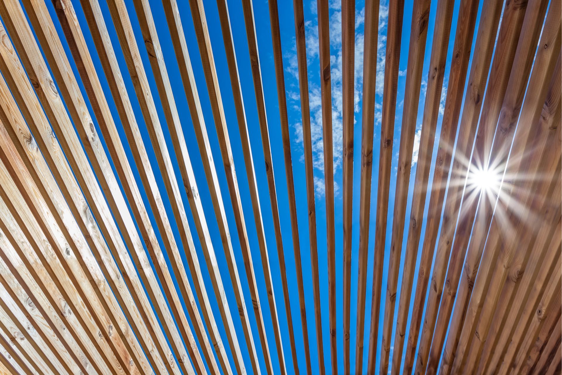 La lumière du soleil filtrant à travers une pergola en bois
