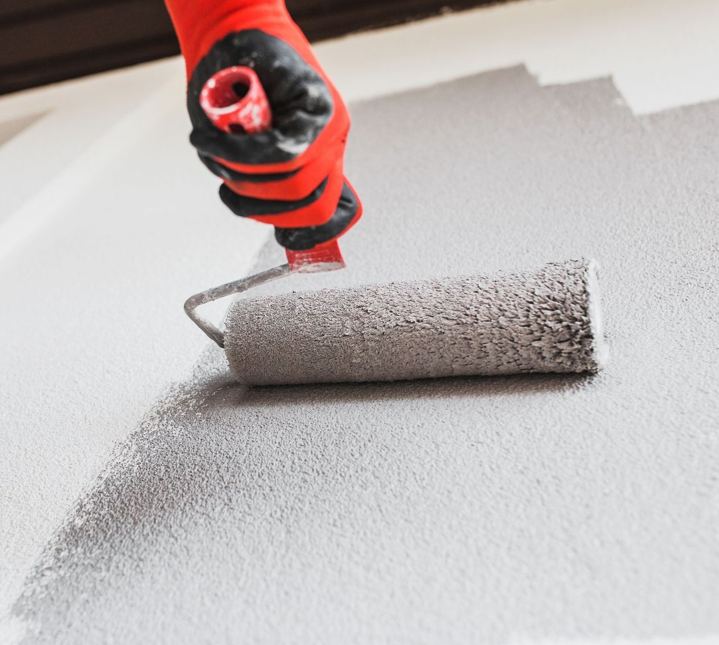 Un rouleau de peinture avec un manche rouge