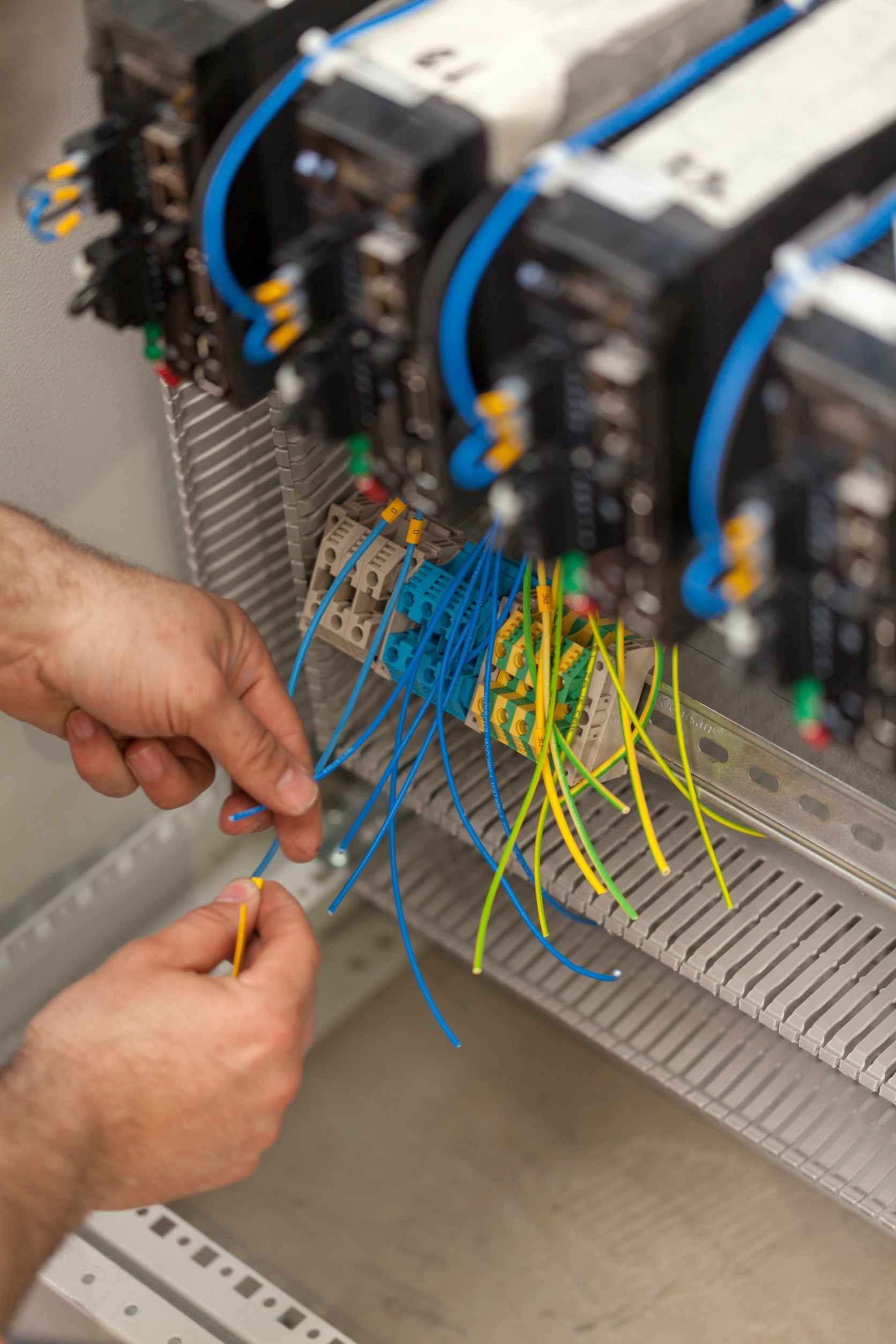 Un hombre está trabajando en un panel eléctrico con un destornillador.