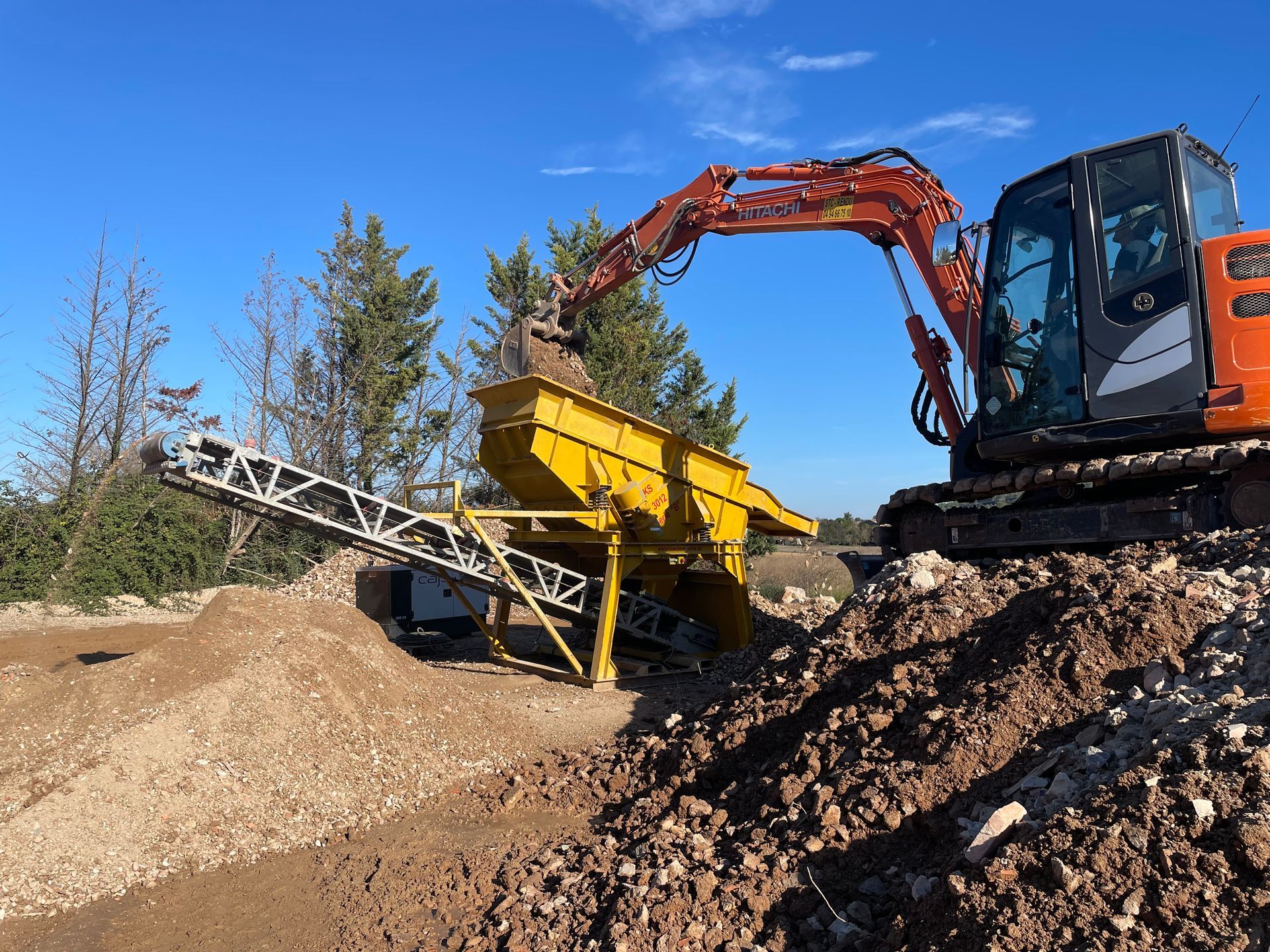 Mini-pelle qui a rempli un crible jaune