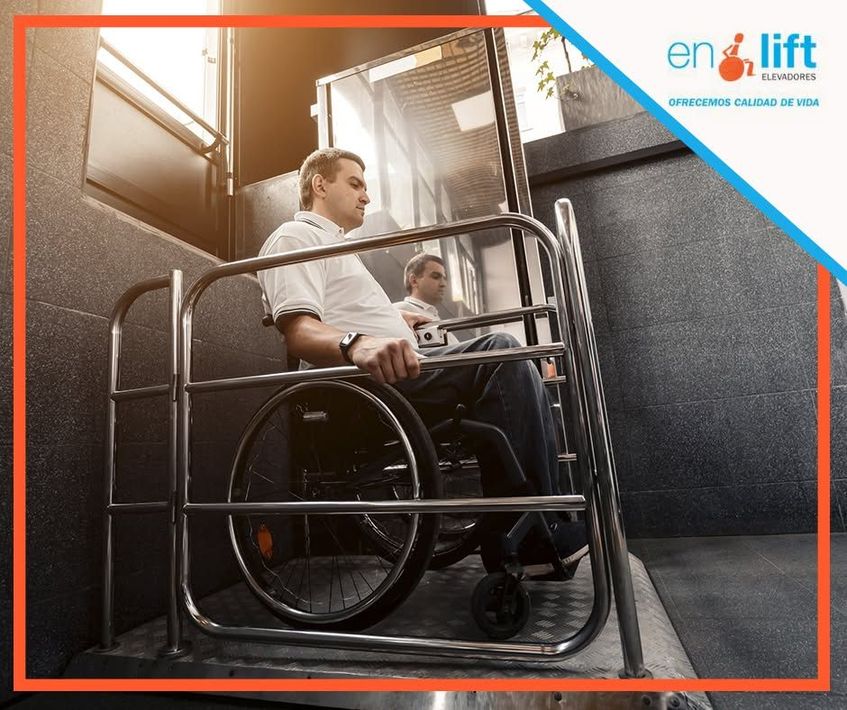 Un hombre en silla de ruedas utiliza un salvaescaleras en una estrecha escalera interior.
