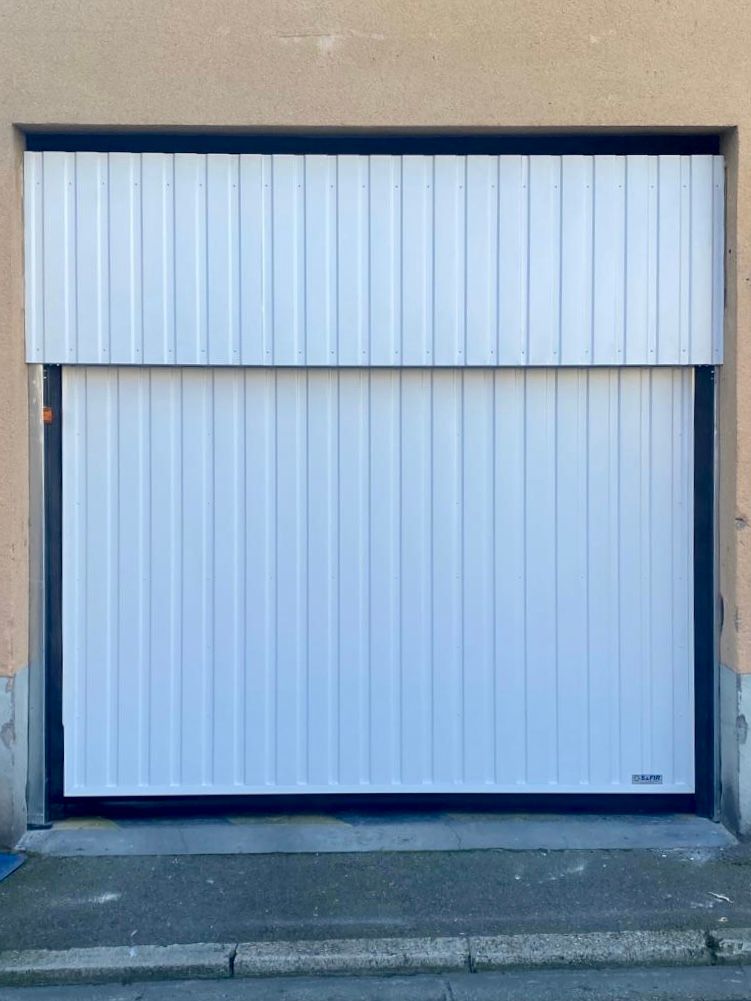 Porte de garage sectionnelle blanche avec panneau horizontal sur une marche en béton