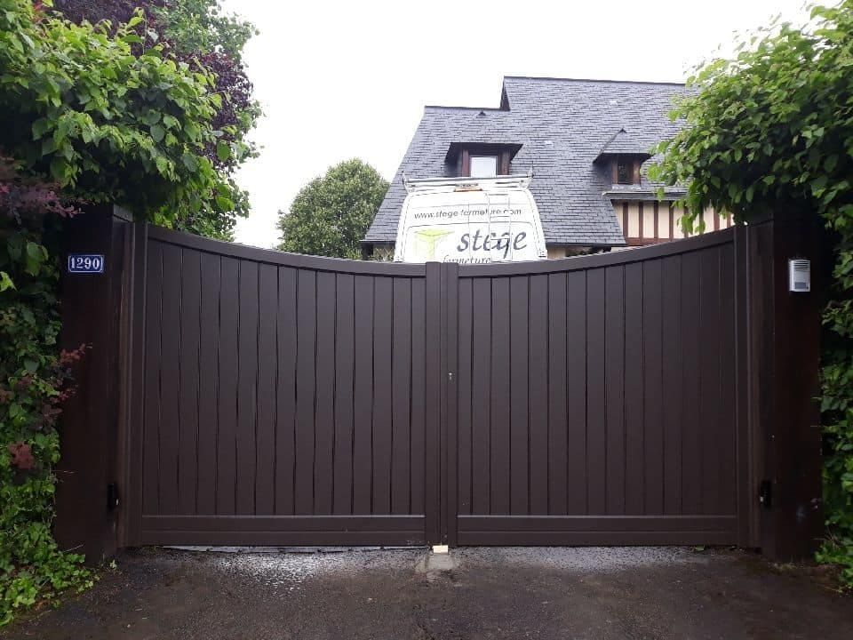 Portail marron foncé fermé devant une maison