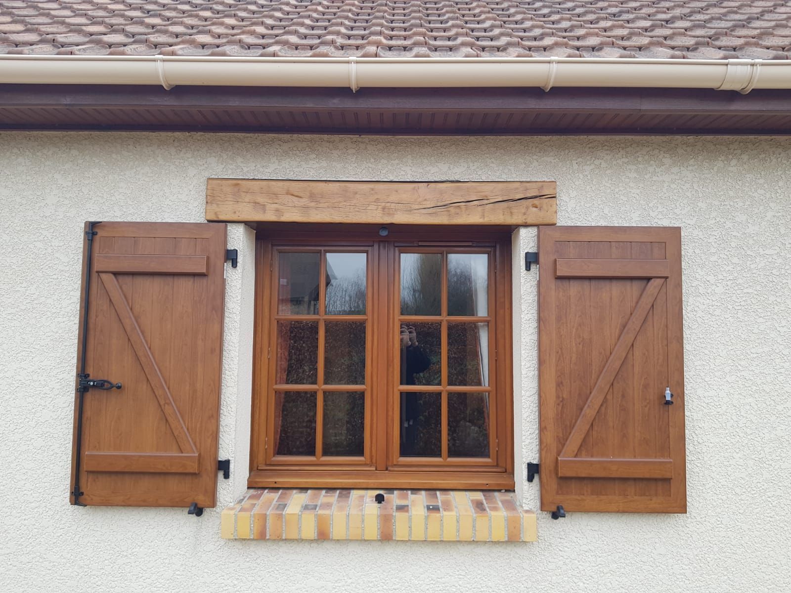 Fenêtre en bois avec volets ouverts sur l'extérieur d'une maison en stuc