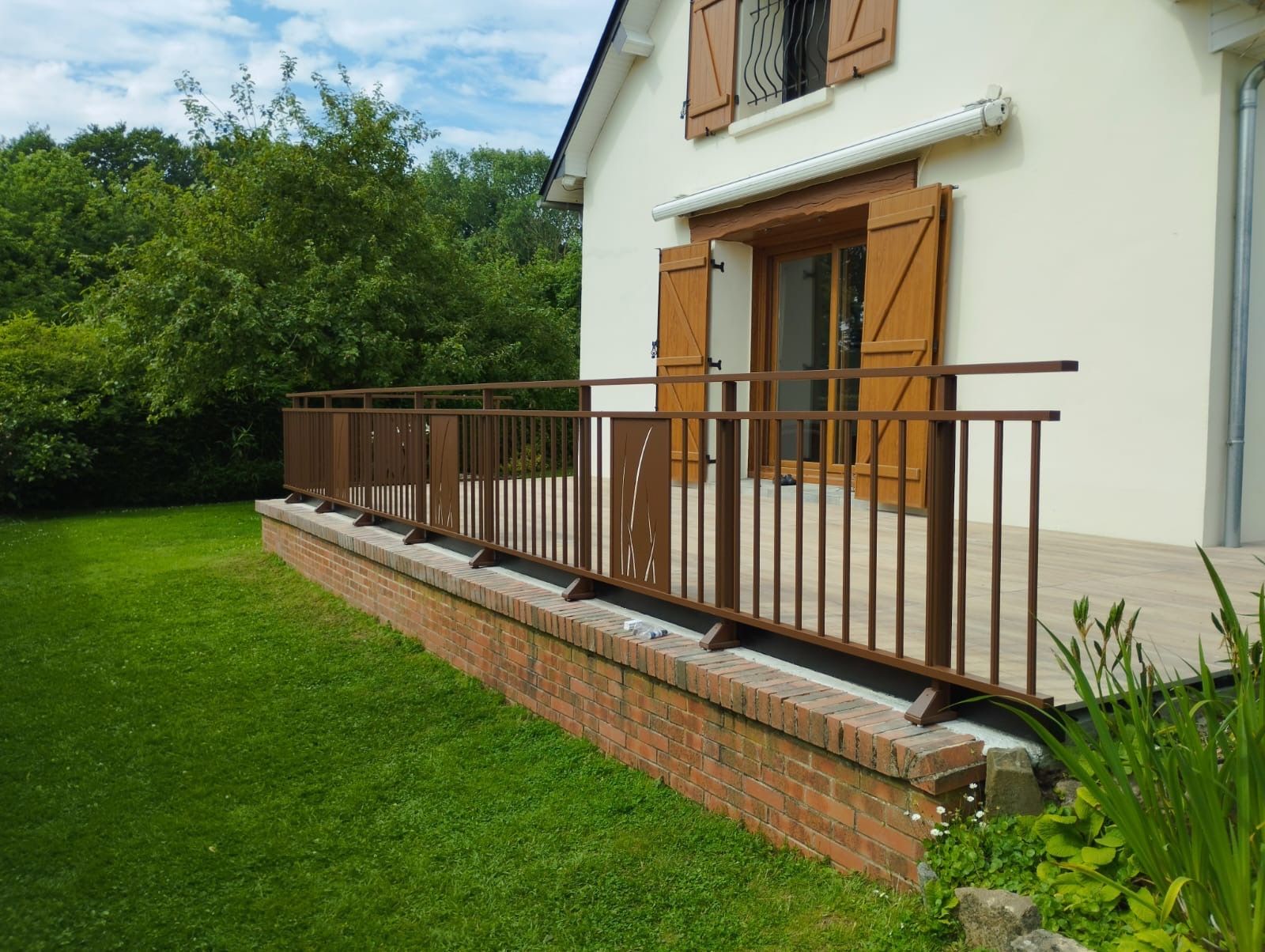 Maison avec porche et marches en bois donnant sur une pelouse verte