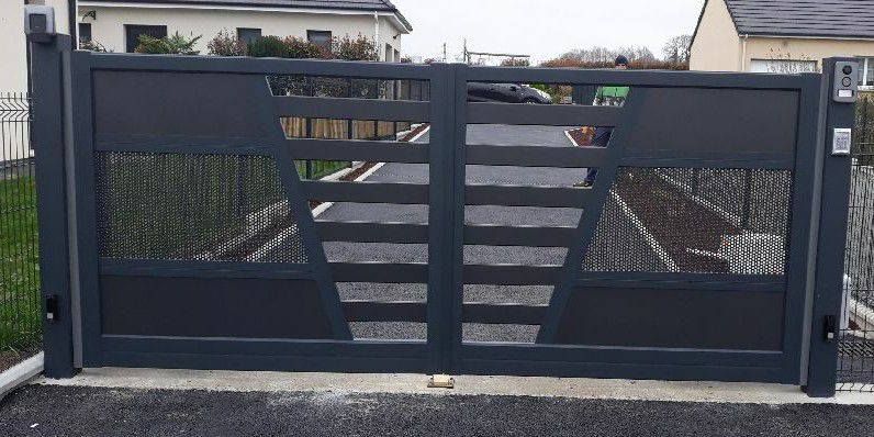 Portail d'allée moderne en métal noir avec lattes horizontales et panneaux grillagés, fermé devant une maison