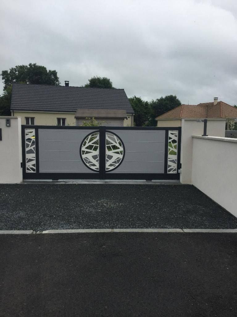 Portail d'allée moderne noir et blanc à motif circulaire sur une allée résidentielle pavée
