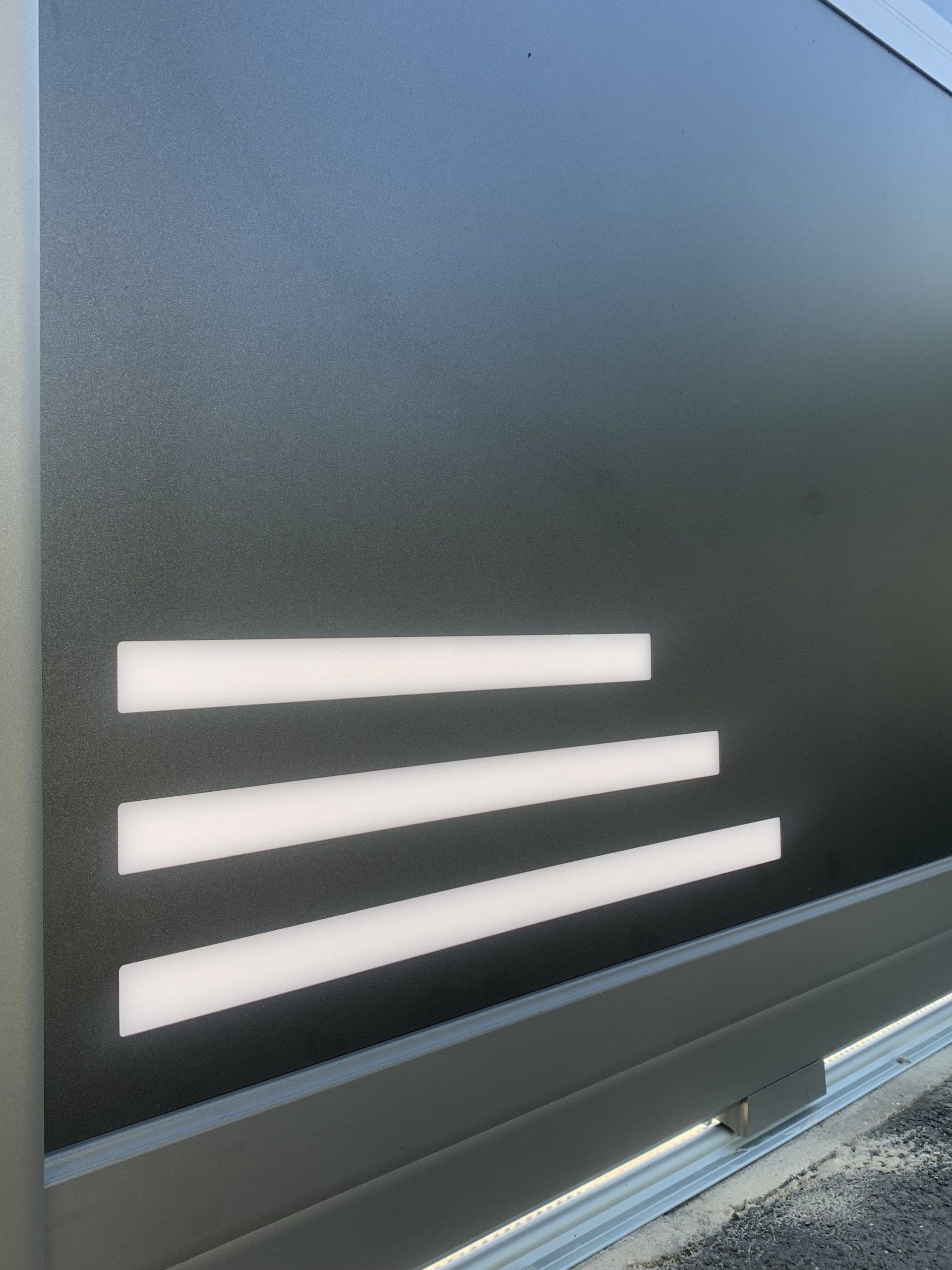 Mur gris foncé avec trois fentes horizontales blanches près du bord inférieur.