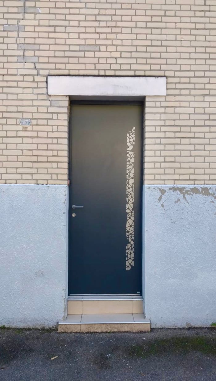 Porte étroite et sombre dans un mur de briques, partie inférieure grise et petite marche en béton