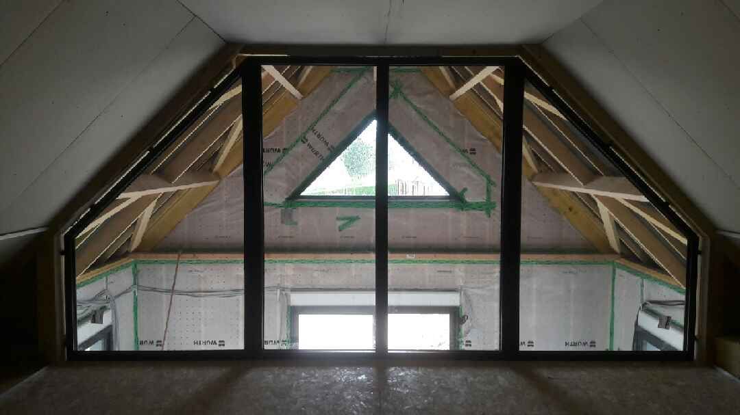 Vue intérieure à travers un cadre de fenêtre triangulaire de grenier en construction