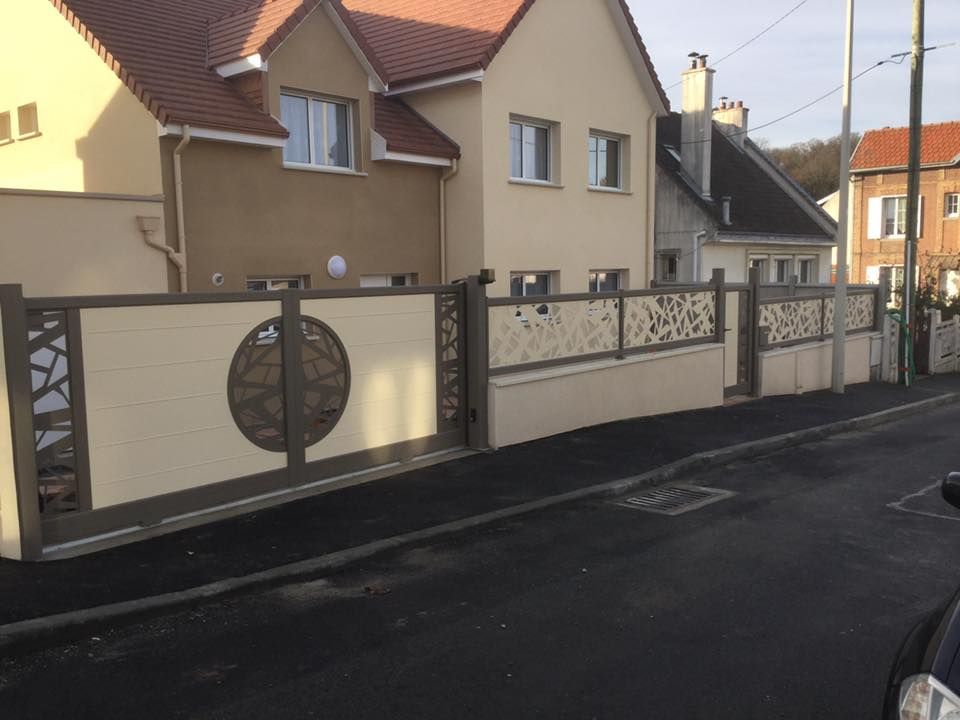 Maison d'habitation aux murs beiges et à la clôture métallique décorative, située dans une rue calme.