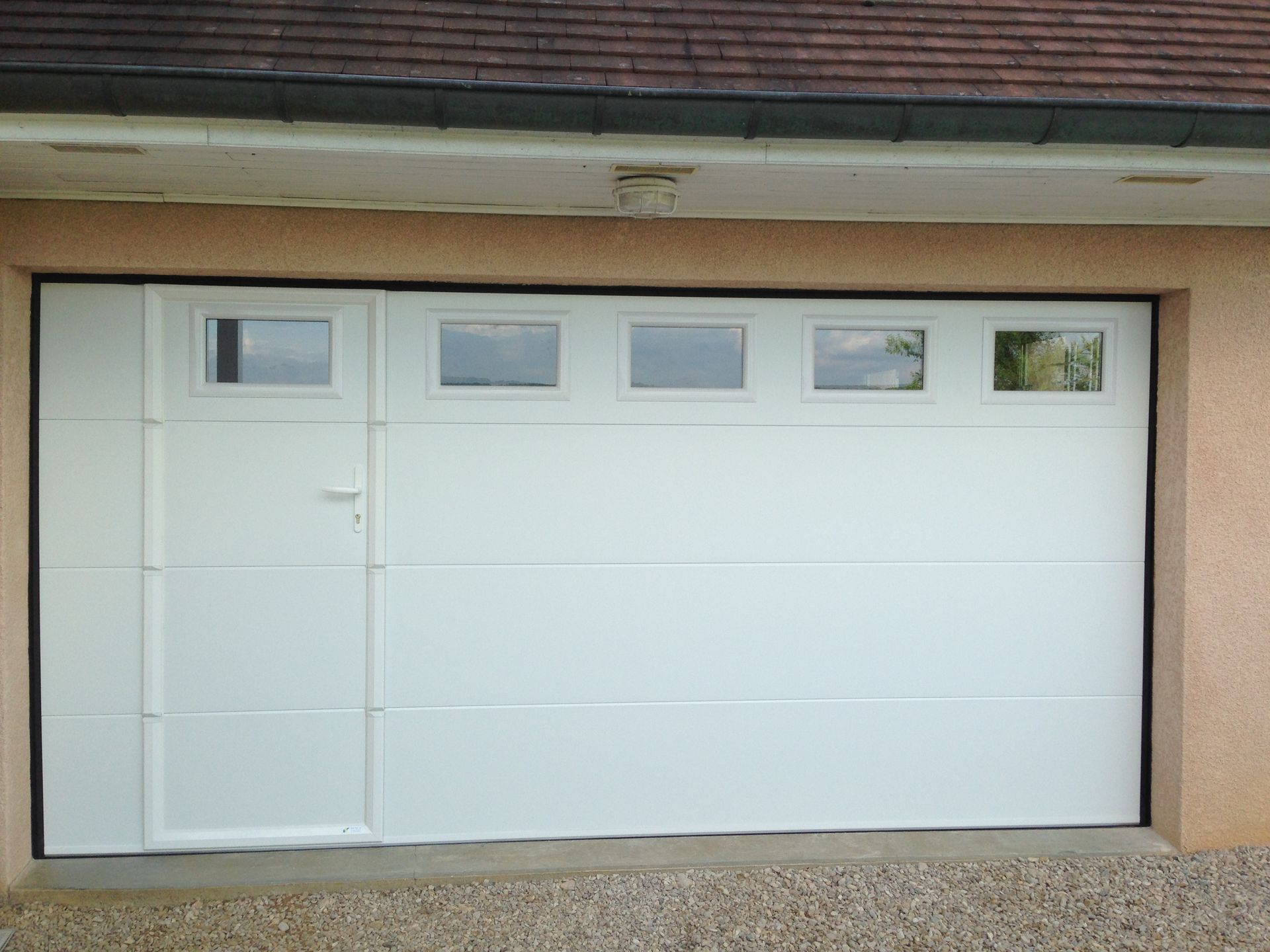 Installation de porte de garage PVC avec une porte de service intégrée