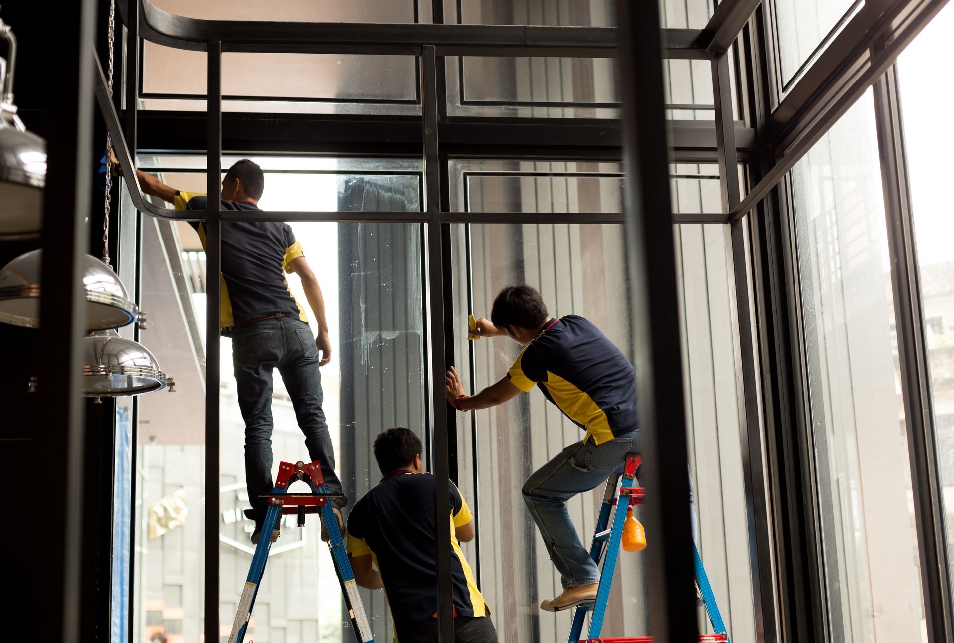 Équipe de trois techniciens changeant un vitrage sur un chantier