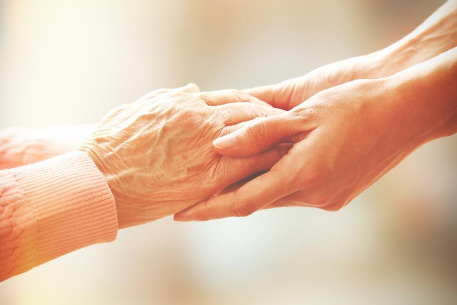 Une personne âgée qui tend ses mains à une autre personne