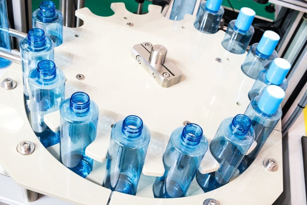 Una cinta transportadora con botellas azules.