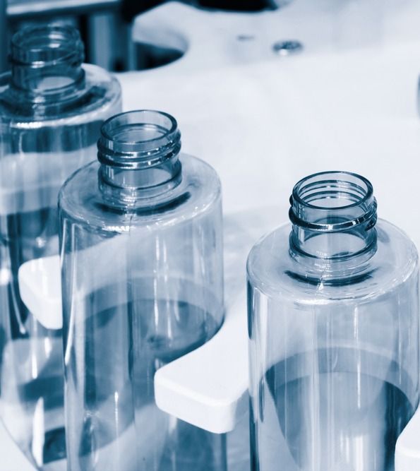 Una fila de botellas de plástico transparente en una cinta transportadora