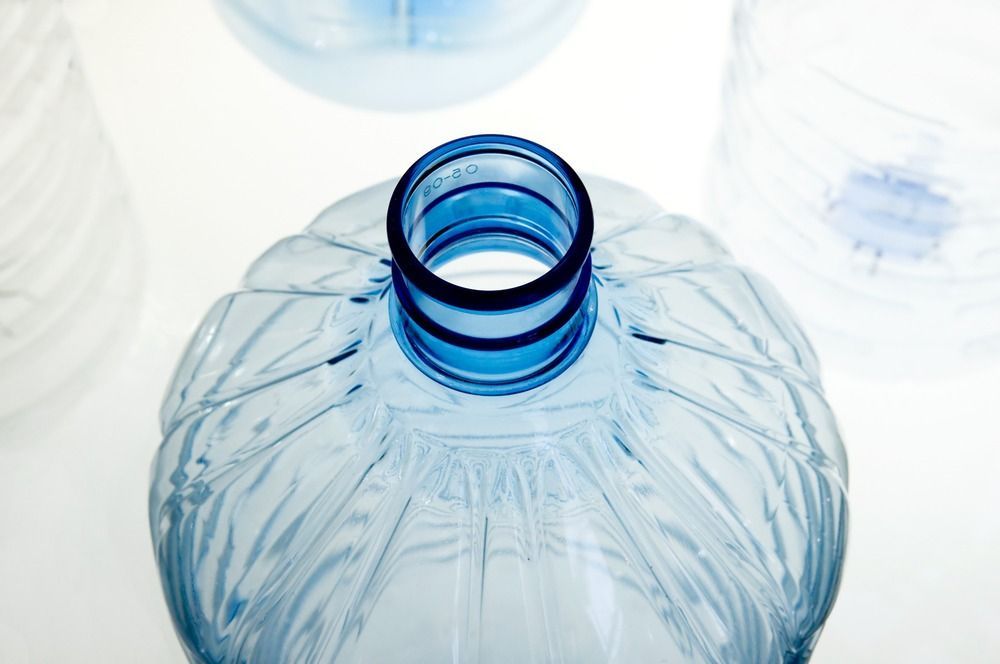 Un primer plano de una botella de plástico azul sobre un fondo blanco.