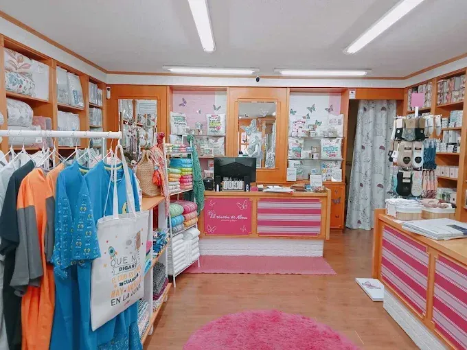 Interior colorido de una tienda minorista con percheros, estantes con productos y mostradores a rayas.