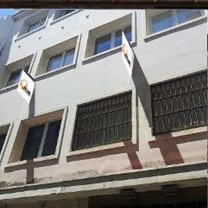 Un gran edificio blanco con muchas ventanas y una bandera en el costado.