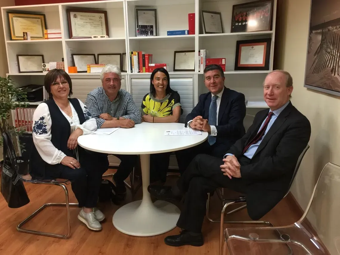 Un grupo de personas están sentadas alrededor de una mesa en una habitación.
