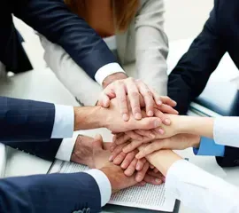 Un grupo de personas junta sus manos.