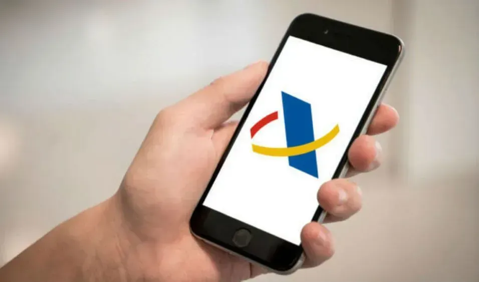 Una persona sostiene un teléfono celular con un logotipo en la pantalla.