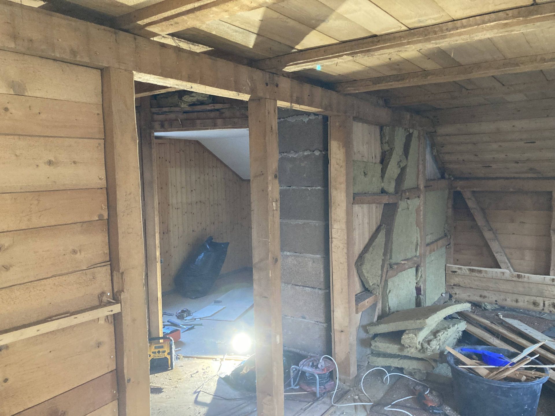 Innenansicht einer im Bau befindlichen Holzkonstruktion mit Rahmen und Isolierung.