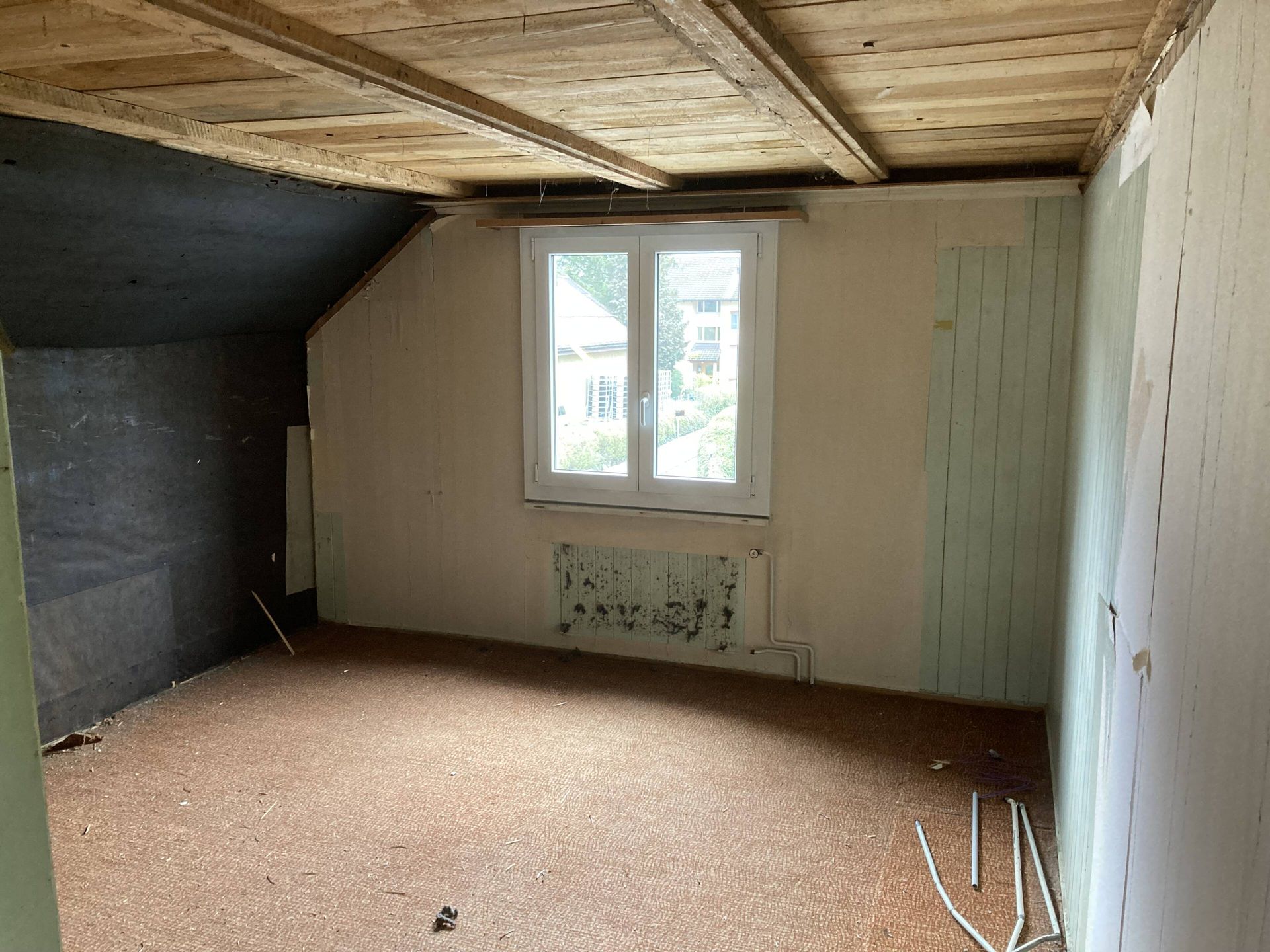 Leerer Raum mit einem Fenster und unfertiger Decke und Wänden.