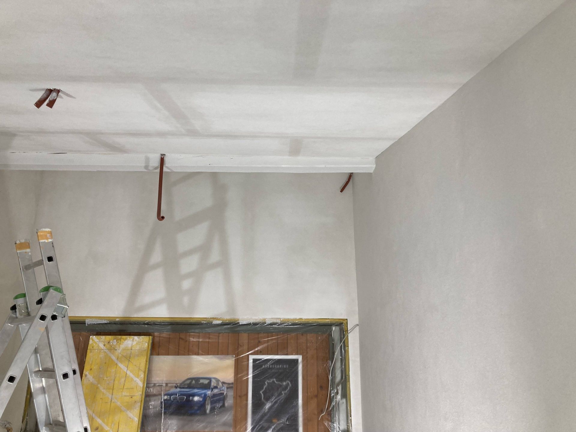 Innenbereich wird renoviert; Wände und Decke weiß grundiert, Zierleisten vorhanden, Leiter vorhanden.