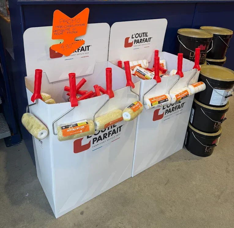Rouleaux et seaux de peinture présentés dans le magasin.