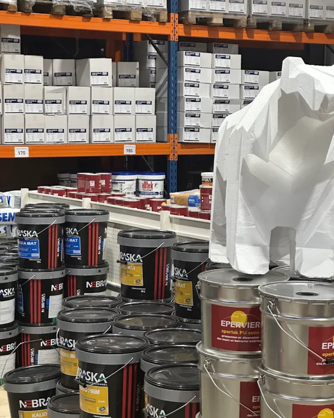 Des étagères remplies de seaux et de boîtes de peinture dans le magasin.