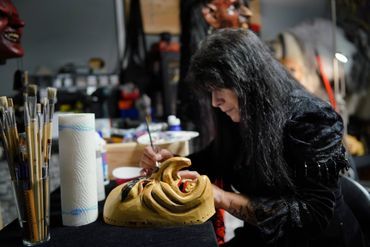 Frau gestaltet eine Maske in ihrer Werkstatt