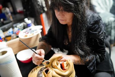 Frau gestaltet eine Maske in ihrer Werkstatt
