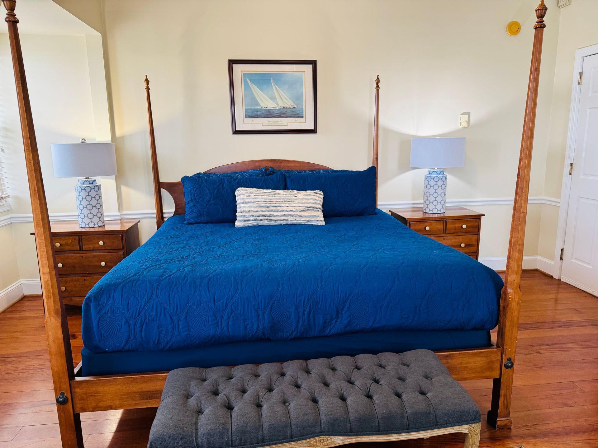 A bedroom with a four poster bed and a bench.