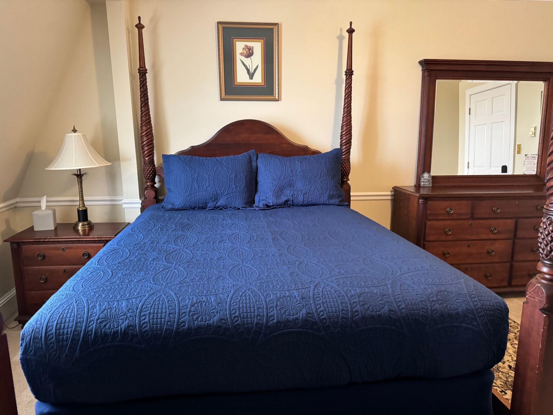 A bedroom with a four poster bed and dresser