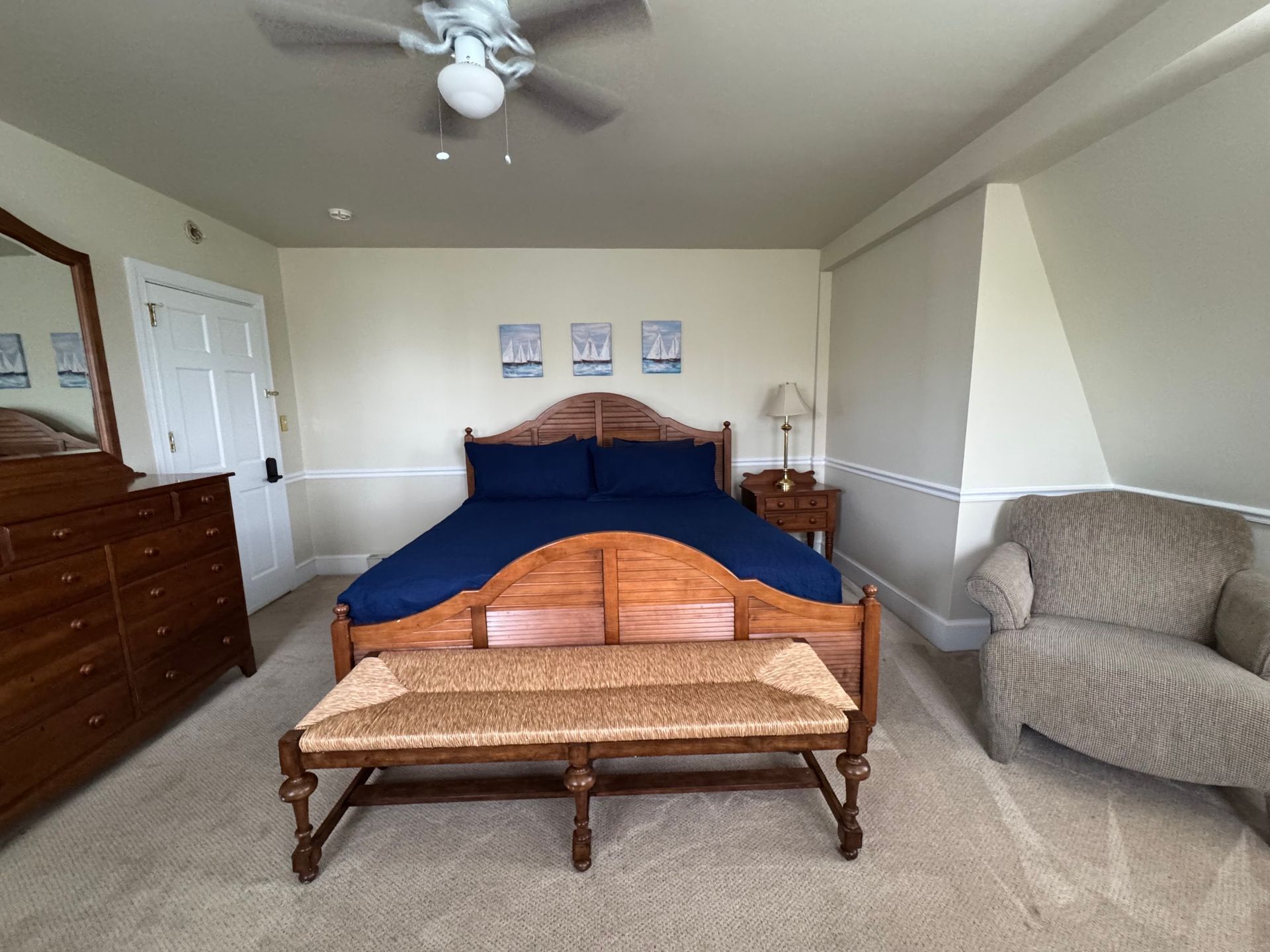 A bedroom with a king size bed and a ceiling fan