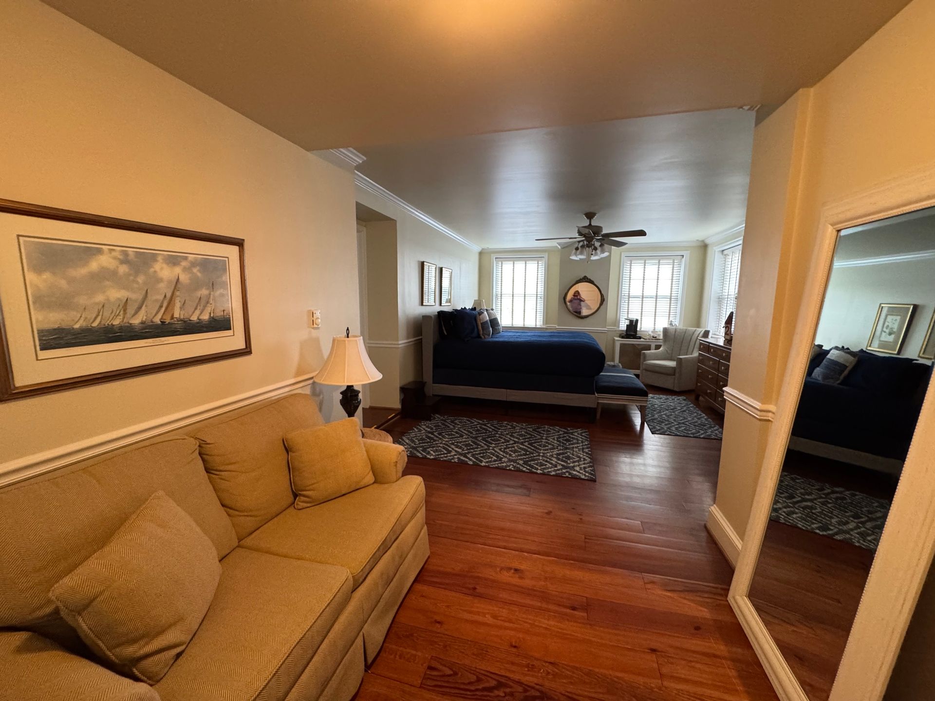 A living room with a couch and a large mirror