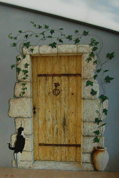 Un chat se tient devant une porte en bois