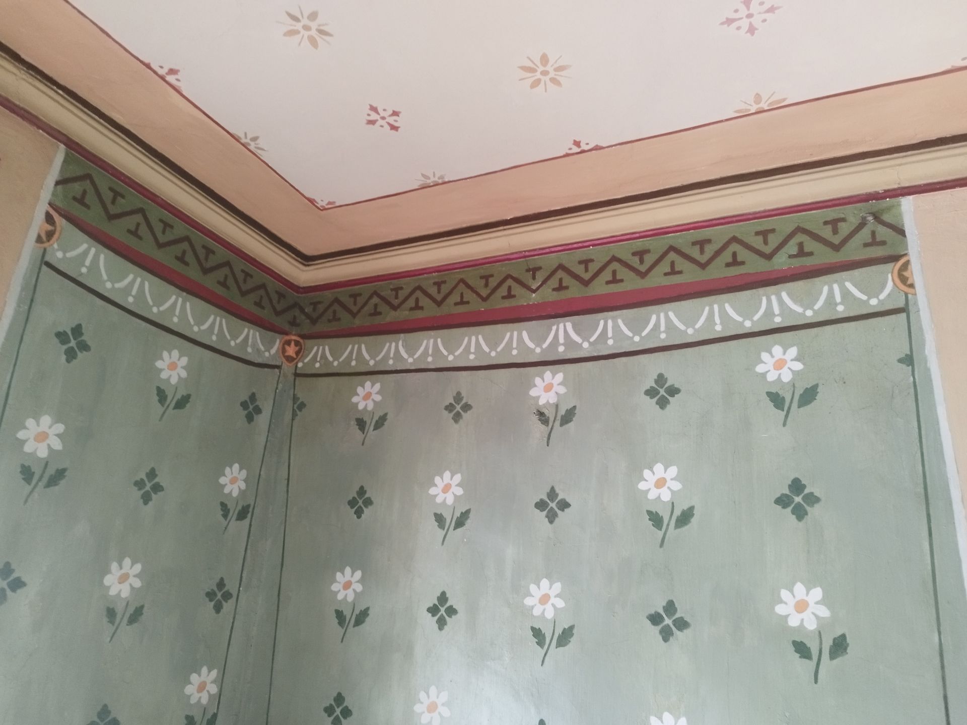 Un coin d'une pièce avec un motif floral sur le mur