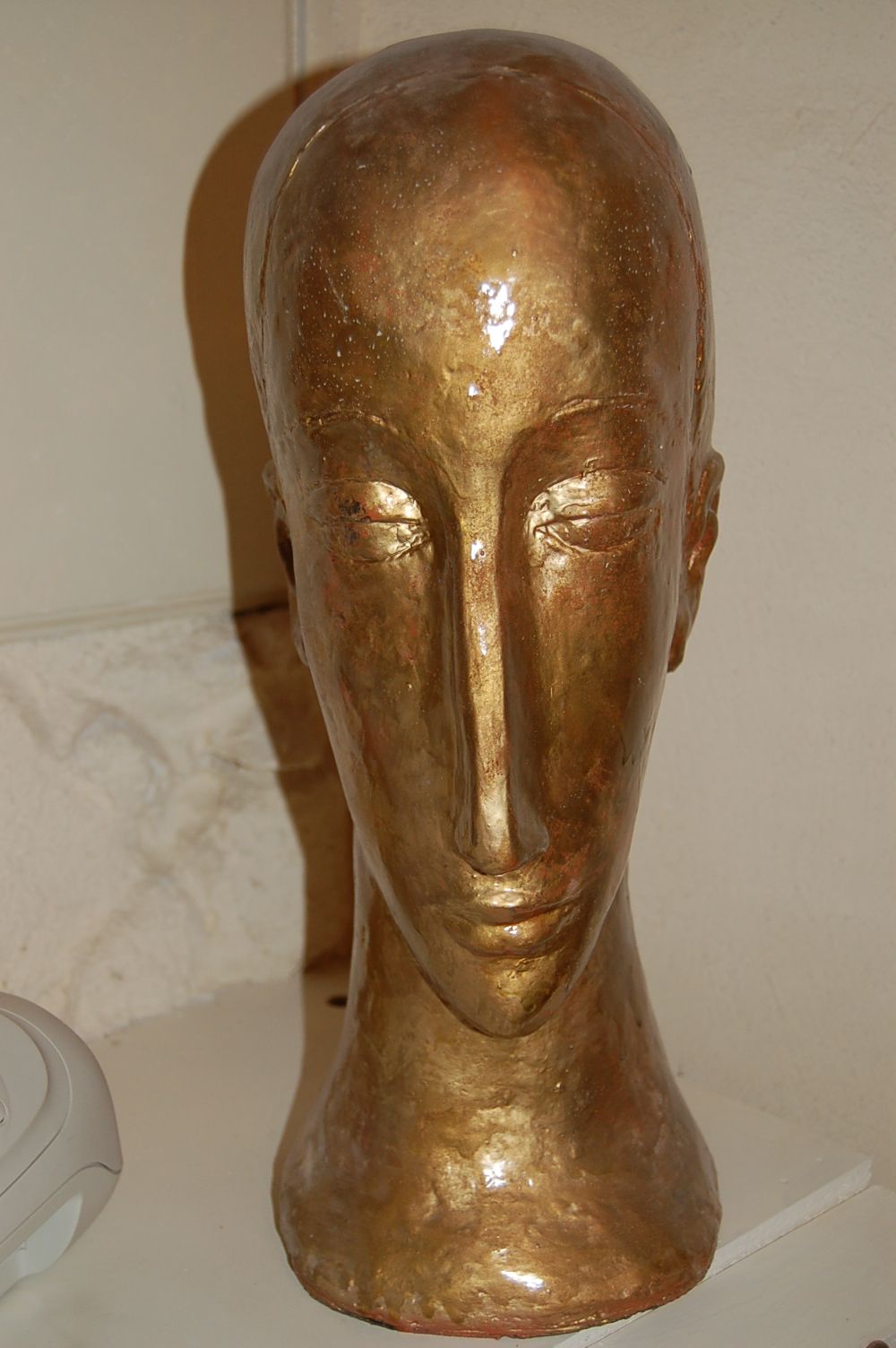 Une statue d'une tête de femme est assise sur une table.