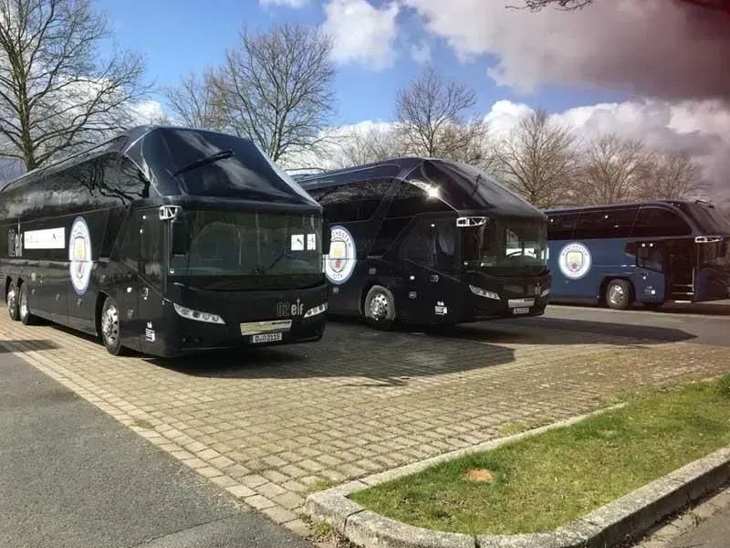 Drei schwarze Busse stehen nebeneinander auf einem Parkplatz. 02elf Travel GmbH & Co KG