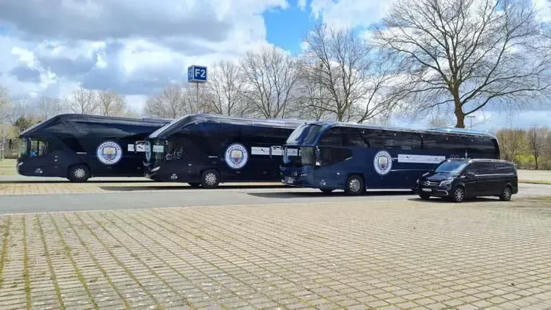 Drei Busse und ein Lieferwagen stehen auf einem Parkplatz. 02elf Travel GmbH & Co KG