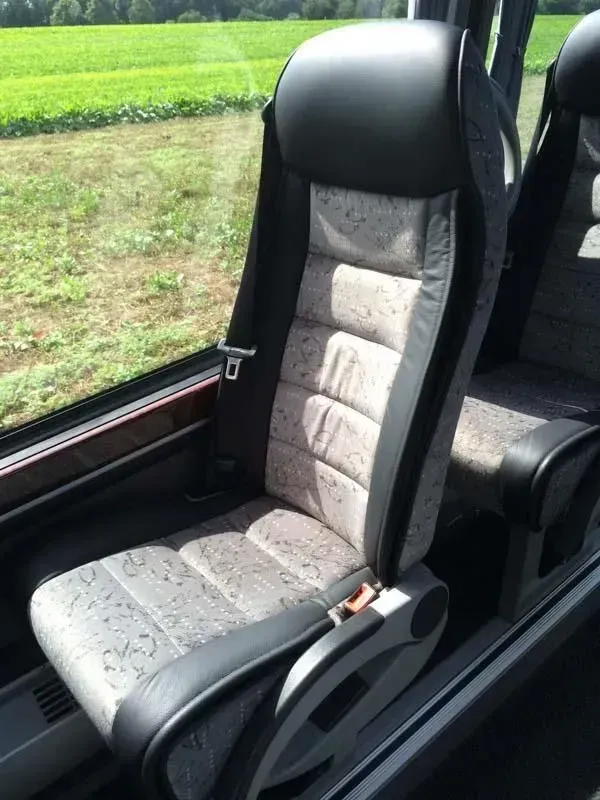 Ein Sitz in einem Bus mit einem Feld im Hintergrund, 02elf Travel GmbH & Co KG