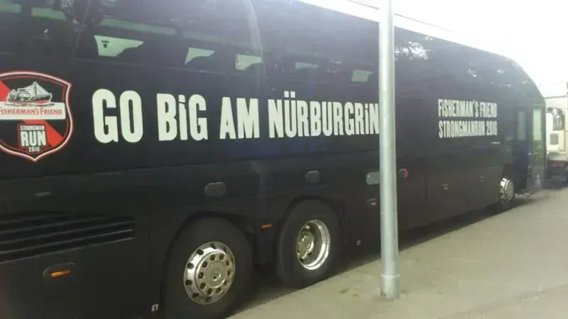 Ein schwarzer Bus mit der Aufschrift „Go Big Am Nürburgring“ an der Seite, 02elf Travel GmbH & Co KG