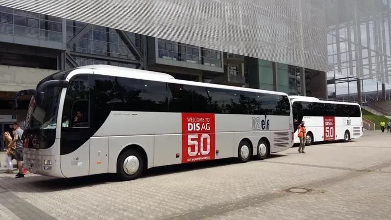 Eine Gruppe Busse parkt vor einem Gebäude. 02elf Travel GmbH & Co KG